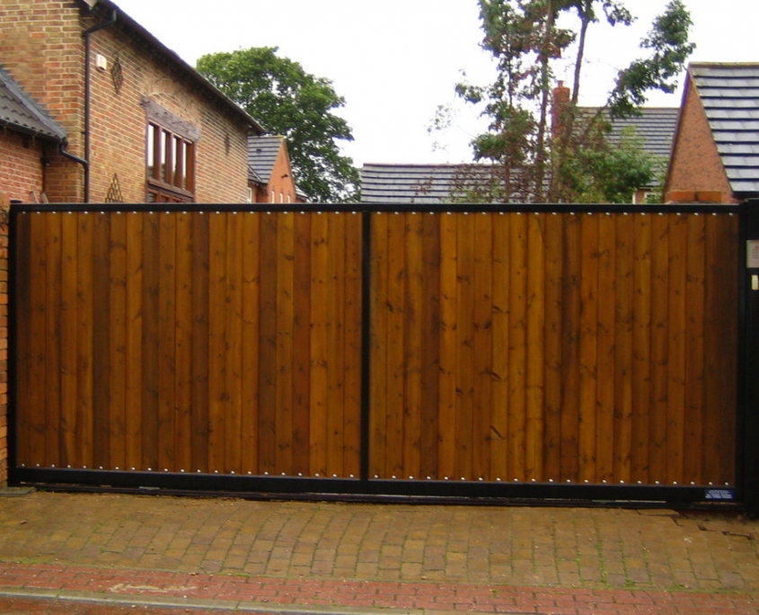 Wooden sliding gate designed to look like twin swing gates